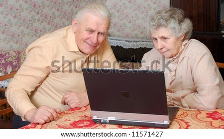 old couple look to the laptop with active interest