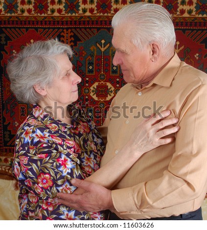 senior women put hands on shoulders her husband and looking to his eyes