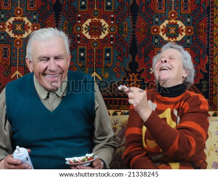 two smiling senior eating dessert
