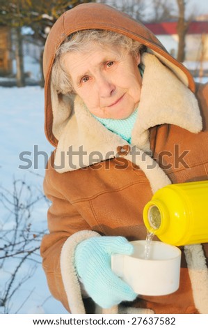 happy granny with thermos on winter background