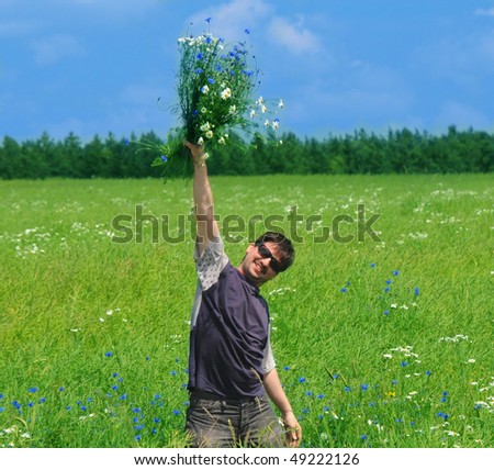 happy young adult man with bouquet of wildflowers