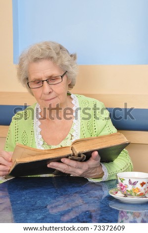 old woman holding a book for reading