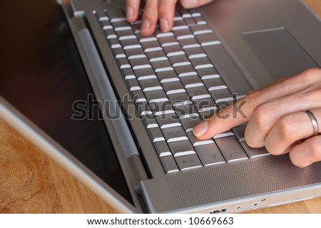 Typing on a laptop - selective focus on index finger of left hand