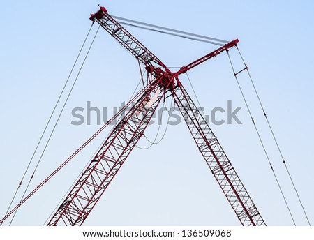 Red crane cross in the construction site.