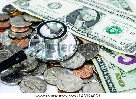 Concept of expensive healthcare with coins, bills, and stethoscope