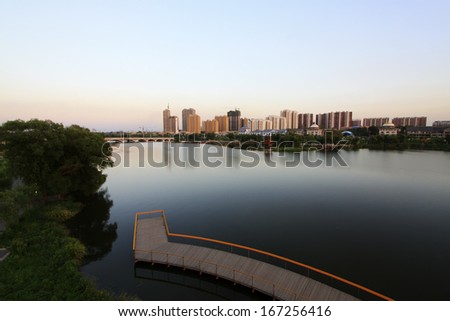 LUANNAN COUNTY, CHINA - AUGUST 30: The High-rise buildings standing at the water\'s edge in the North River Park, on August 30, 2013, LuanNan county, Hebei province, China.