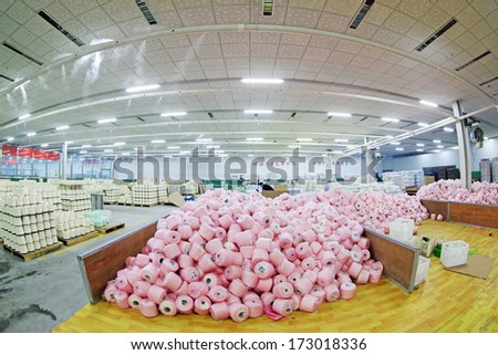 LUANNAN COUNTY, CHINA - DECEMBER 20: The cotton reel thread piled up together in a production workshop, in the ZeAo spinning LTD., on December 20, 2013, Luannan county, hebei province, China.