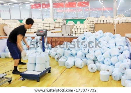 LUANNAN COUNTY - DECEMBER 20: The workers were packing cotton reel thread in a production workshop, in the ZeAo spinning LTD., on December 20, 2013, Luannan county, hebei province, China.