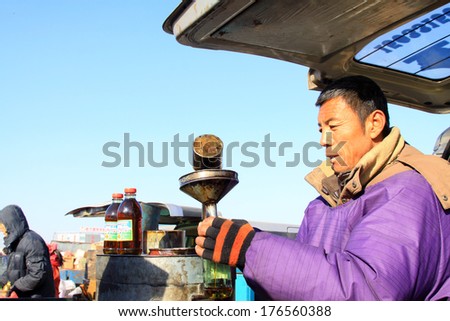 LUANNAN COUNTY - JANUARY 28: Vendor busy filling balm, in refined balm booth, on january 28, 2014, Luannan county, Hebei province, China.
