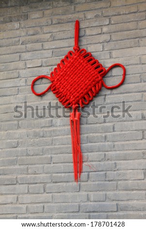yellow Chinese knot on the red wall, closeup of photo