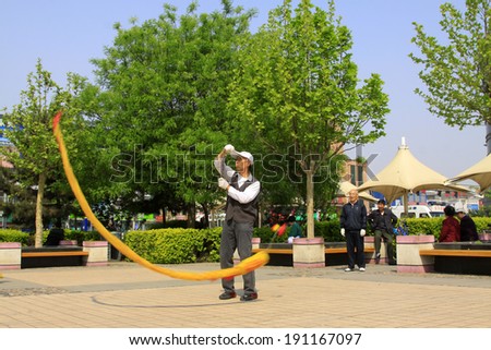 LUANNAN COUNTY, CHINA - APRIL 29: An old man was shaking diabolo on the Square, on april 29, 2014, Luannan county, Hebei province, China