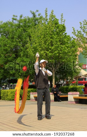 LUANNAN COUNTY, CHINA - APRIL 29: An old man was shaking diabolo on the Square, on april 29, 2014, Luannan county, Hebei province, China