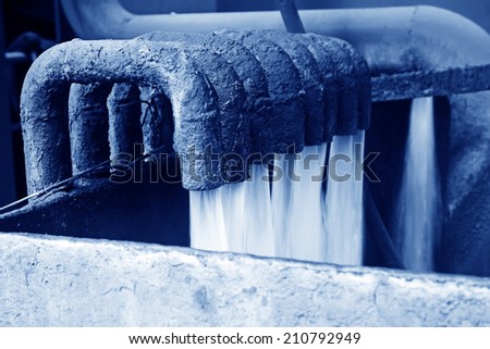 water flowing from pipe in industrial high pressure equipment, closeup of photo