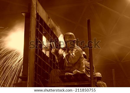 TANGSHAN - JUNE 19: workers welding mechanical parts in the workshop, on June 19, 2014, Tangshan city, Hebei Province, China