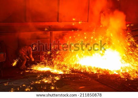 iron works blast furnace taphole spewing molten iron, closeup of photo