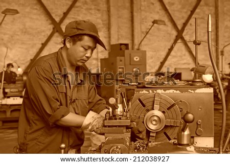 TANGSHAN CITY - JUNE 20: worker working in the machine tool in the production workshop, on June 20, 2014, Tangshan city, Hebei Province, China