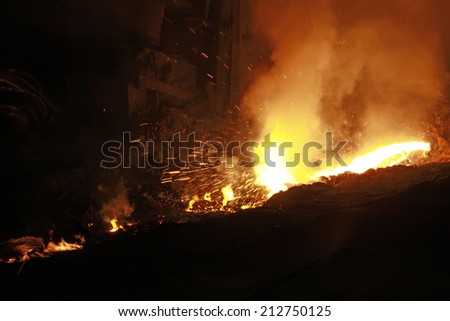 hot molten iron flowing from blast furnace, closeup of photo