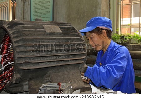 TANGSHAN - JUNE 20: Women workers repairing electrical machine in a factory, on June 20, 2014, Tangshan city, Hebei Province, China
