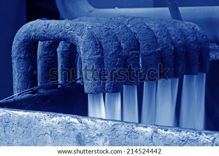 water flowing from pipe in industrial high pressure equipment, closeup of photo