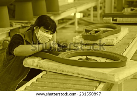 LUANNAN COUNTY - JANUARY 5: The women workers repair ceramic semi-finished products in a warehouse, in the ZhongTong Ceramics Co., Ltd. January 5, 2014, Luannan county, Hebei Province, China.