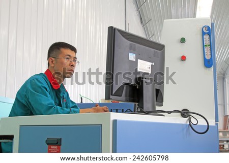LUANNAN COUNTY - AUGUST 23: technicians staring at computer monitors in a production line, on august 23, 2014, Luannan County, Hebei Province, China