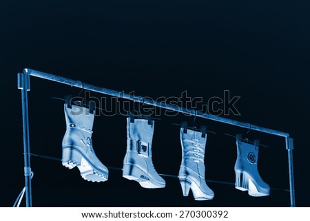 women's boots hanging in the blue sky, closeup of photo