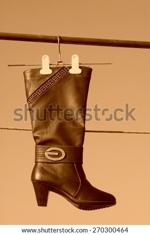 women's boots hanging in the blue sky, closeup of photo