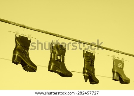 women\'s boots hanging in the blue sky, closeup of photo