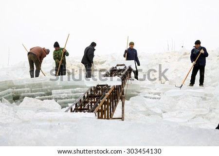 LUANNAN COUNTY - JANUARY 24: Farmers transport ice with a conveyor belt in the winter on January 24, 2015, Luannan County, Hebei Province, China