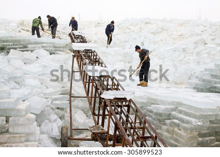LUANNAN COUNTY - JANUARY 24: Farmers transportation ice with a conveyor belt in the winter on January 24, 2015, Luannan County, Hebei Province, China
