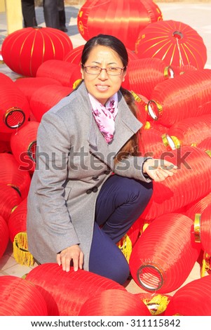 LUANNAN COUNTY - MARCH 5: On the Lantern Festival Day, a woman sitting in the middle of red lantern, March 5, 2015, luannan county, hebei province, China