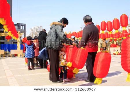 LUANNAN COUNTY - MARCH 5: On the Lantern Festival Day, people were busy with hanging red lanterns in a park, March 5, 2015, luannan county, hebei province, China