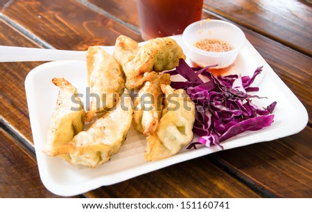 Pan Fried Dumpling with sauce on wood table