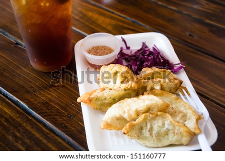 Pan Fried Dumpling with sauce on wood table