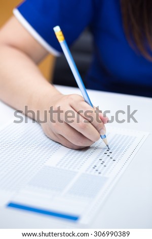 Student filling out answers to blue answer sheet with blue pencil
