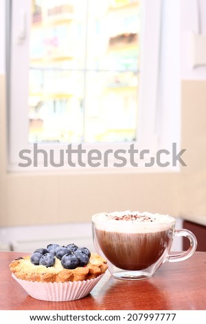 Morning coffee with cake on the background of the window in the kitchen
