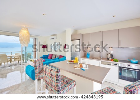Luxury cozy light kitchen interior with fancy modern color furniture, marble floor,  terrace and sea view in Bodrum Turkey  with sea and terrace and food served -  Sucessful sea life concept