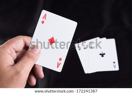 hand holding playing cards on black background