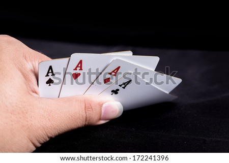 hand holding playing cards on black background