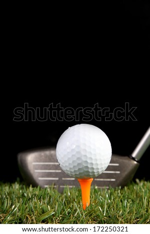 Golf club ready to hit golf ball on black background