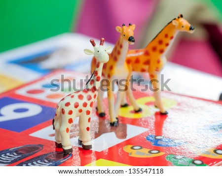 Plastic giraffe toy isolated on colorful background for playful kids