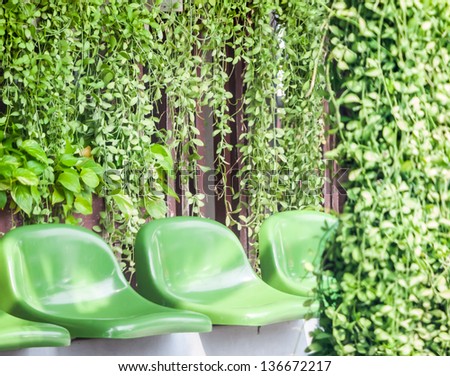 Plastic chairs among green garden. Concept of becoming a part of nature.