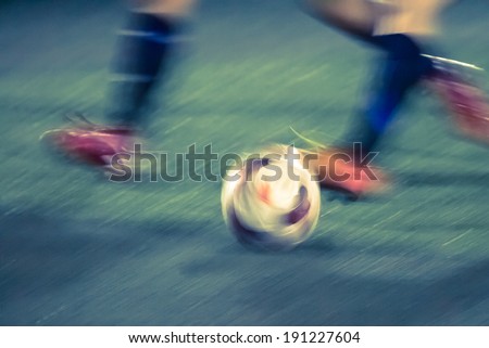 Football player\'s foot kicking the ball shot in motion blur