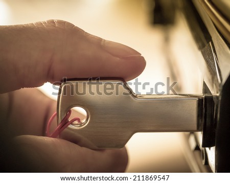 Macro image of a hand plugging key-shaped USB drive into car audio in concept of mobile entertainment technology