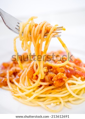 Spaghetti bolognese with pork in tomato sauce isolated on white plate