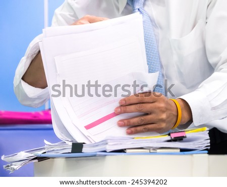 Businessman\'s hand holding papers in concept of busy searching for the important document