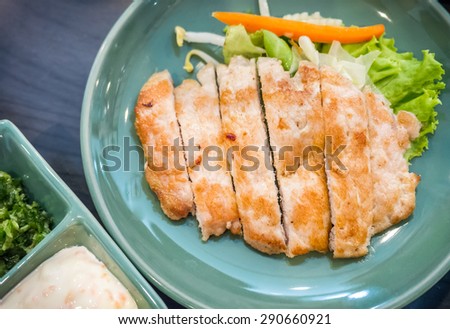 Cut pork steak served in the green plate with dipping sauce