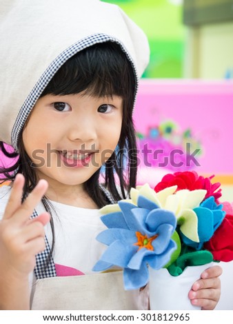 Adorable asian girl role playing florist occupation wearing uniform