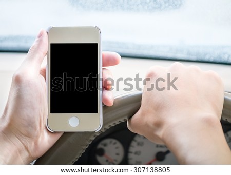 Driver holding blank screen smartphone in the car while driving in slightly rain