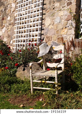 empty white chair outdoors by a stone building